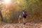 Autumn nature hiker team young women walking in national park with backpack. Woman tourist going camping in forest, select focus