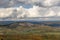 Autumn nature view from mountain to the horizon with hills and mountains and stone pit and cloudy sky