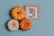 Autumn October flat lay. Orange mini pumpkins and calendar date in wooden frame. Halloween day. Blue background. Oak leaves. Fall