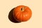 Autumn orange pumpkin closeup beige background