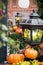 Autumn outdoor decorations at the festival. Orange pumpkin and retro forged lanterns with maple leaves,flowers