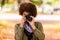 Autumn outdoor portrait of beautiful African American young woman holding a digital camera - Black people