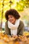 Autumn outdoor portrait of beautiful African American young woman lying down - Black people