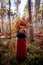 Autumn outdoor portrait of beautiful happy girl walking in park or forest with bouquet of dry fern leaves, magic, mistical mood