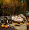 Autumn outdoor still life with pumpkin cinnamon buns in oval glass dish on wooden table