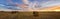 Autumn panorama rural field with cut grass at sunset