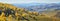 Autumn panoramic view. Yellow trees on the hillside, blue haze