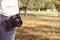 Autumn photo with girl standing in a park with camera