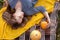 Autumn picnic, woman under the yellow knitted plaid, pumpkins, top view.