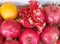 Autumn Pomegranates and an Orange displayed at a Farmers Market