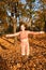 Autumn portrait of adorable smiling little girl child preteen having fun and jumping in leaves in the park