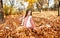 Autumn portrait of adorable smiling little girl child preteen having fun in the park
