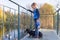 Autumn portrait of boy child with dachshund dog on bridge in sunny park