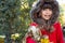 Autumn portrait of cute curly girl. Kid gathering yellow fall foliage.