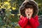 Autumn portrait of cute curly girl. Kid gathering yellow fall foliage