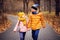 Autumn portrait of happy brother and sister walking the road in sunny park