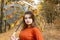 Autumn portrait. Young girl with an umbrella with leaves on the background of a bright yellow forest