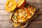 Autumn pumpkin casserole with mozzarella cheese and herbs close-up in a baking dish. Horizontal top view