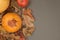 Autumn Pumpkin Thanksgiving Background - orange pumpkin and red apples over fall leaves on gray table. copy space.