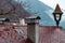 Autumn rainy day time water drops on bare branches and house roof top with vintage chimney architecture landmark rural view moody