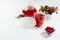 Autumn red herbal tea in transparent teapot, cup with dry leaves, rose hip, hawthorn berries in sunlight on white wood table.