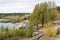 Autumn river beach with wooden paths, wind shakes trees