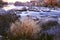 Autumn river with a swift current, rapids, rocks