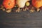 Autumn rustic background flat lay. Pumpkins, autumn leaves, anise, acorns, cinnamon border on dark wood with space for text. Happy