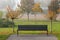 Autumn sakura trees and bench in the park