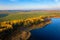 Autumn scene on lake shore aerial view. Autumn nature landscape from above. Yellow forest on lakeside