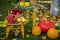 Autumn scene with plants, pumpkins, apples in a wicker basket, ceramic pots, wooden chair, vintage style, composition in the garde