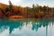 Autumn scenery of Aoi-Ike Blue Pond with beautiful fall colors on the lakeside hills reflected