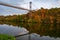 Autumn scenery with colorful trees reflected in the water. Pedestrian bridge across Teteriv river, Zhytomyr, Ukraine