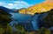 Autumn scenery of a dam in Tateyama Kurobe Alpine Route, Japan with colorful foliage on lakeside