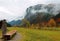 Autumn scenery of a farmland by Karwendel Mountain with a wooden trough on the grassy field