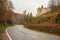 Autumn scenery of winding road, colorful trees and Pieskowa Skala castle in Ojcow National Park, Poland