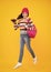 Autumn school holiday. Back to school. Teenager schoolgirl in autumn clothes on yellow isolated studio background. Happy