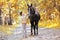 Autumn season happy teenager boy and horse walking