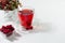 Autumn season red herbal tea in elegant transparent cup with dry leaves, rose hip, hawthorn berries in sunlight on white wood.