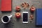 Autumn season still life with red apples, books, mobile device, black coffee cup and fall leaves over rustic wooden background. Kn