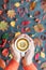 Autumn season.Top view on man hand holding cup of hot tea with lemon, autumn leaves, ripe rosehip, hawthorn, rowan berries on