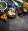 Autumn seasonal cooking ingredients with harvest vegetables, greens and mushrooms on dark rustic wooden background