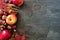 Autumn side border of apples, fall foods & decor on dark stone