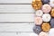 Autumn side border of dusty rose, white, gold and gray pumpkins on a white wood background