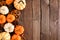 Autumn side border of pumpkins and natural fall decor on a rustic dark wood background