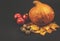 Autumn sill life - pumpkin, apples, walnuts and leaves on black background