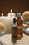 Autumn spa aromatherapy composition with essential oil bottles, bath bombs and lit candles on wooden background.