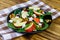 Autumn spinach salad with apple, feta cheese, walnut and dried cranberry on wooden table. Healthy vegetarian food