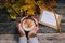 Autumn start composition still life. Woman`s hands with cup of coffee, cappuccino, latter. autumn leaves, craft envelope