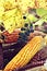 Autumn still life of a bunch of grapes, ears of colored corn and leaves, close-up